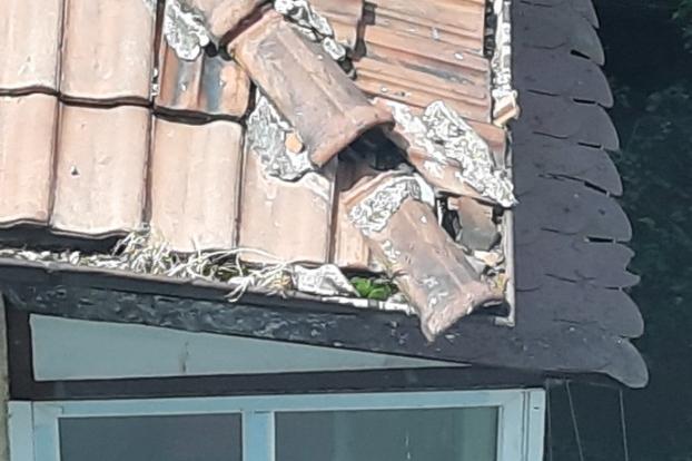 Висяща керемида от покрива на жилищна сграда